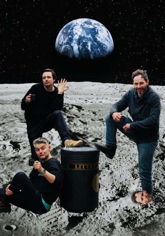 Three performers in front of a simulated background displaying a photograph of earth as seen from the surface of the moon. There's a bin in between the three performers. One of the performers has a foot propped on the bin, and their other foot is a face. The second performer also has a foot propped up on the bin, is holding up a hand, and their other hand is holding a mug. The third performer is leaning with their back to the bin, and is holding up a mug in a toast to the camera. 