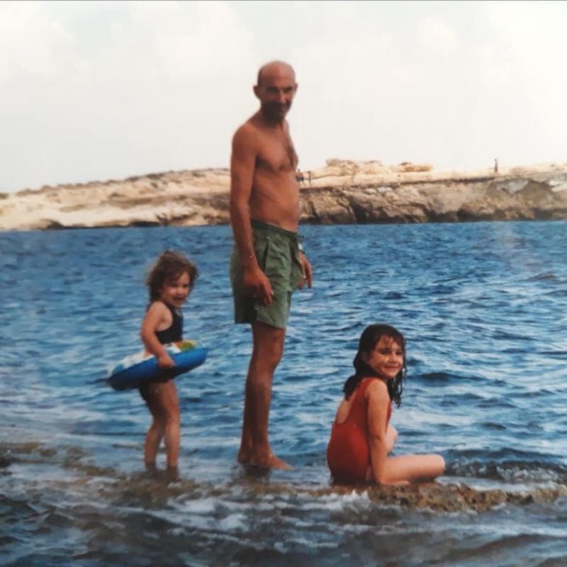 Two girls with their dad next to the water