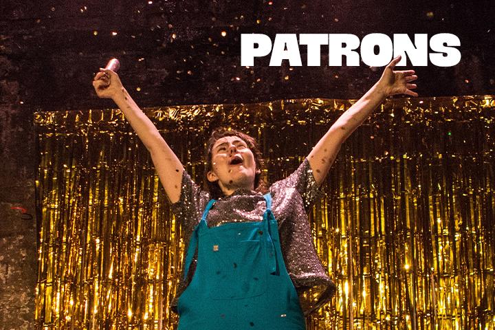 Fran Bushe in front of a gold fringe curtain and balloons.