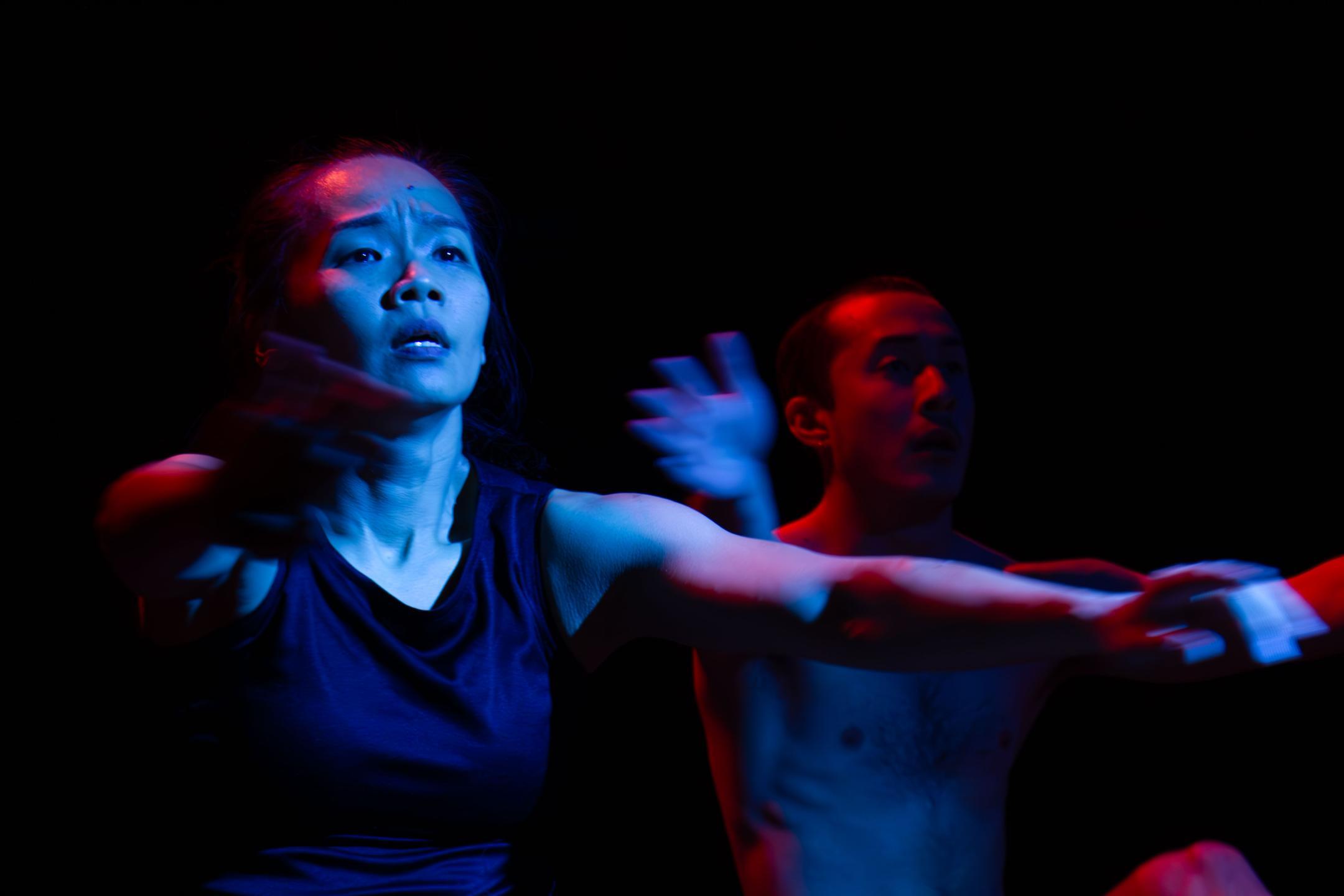 two performers under blue and red light 