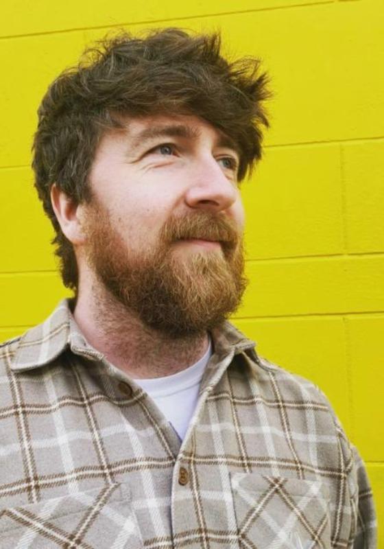 Man stands in front of yellow wall