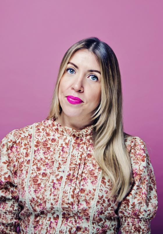 Louise in a floral dress against a pink background