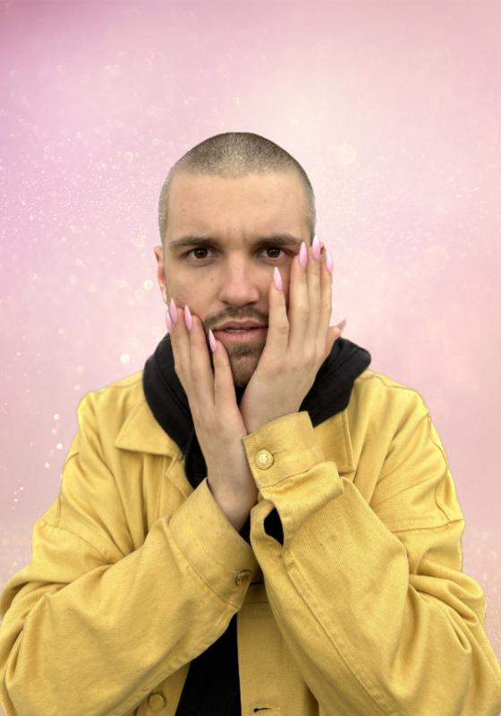 Will with his hands either side of his face with long pink nails against a glittery pink background
