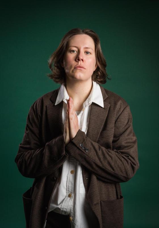 Chloe Petts looking at the camera with her hands held in prayer