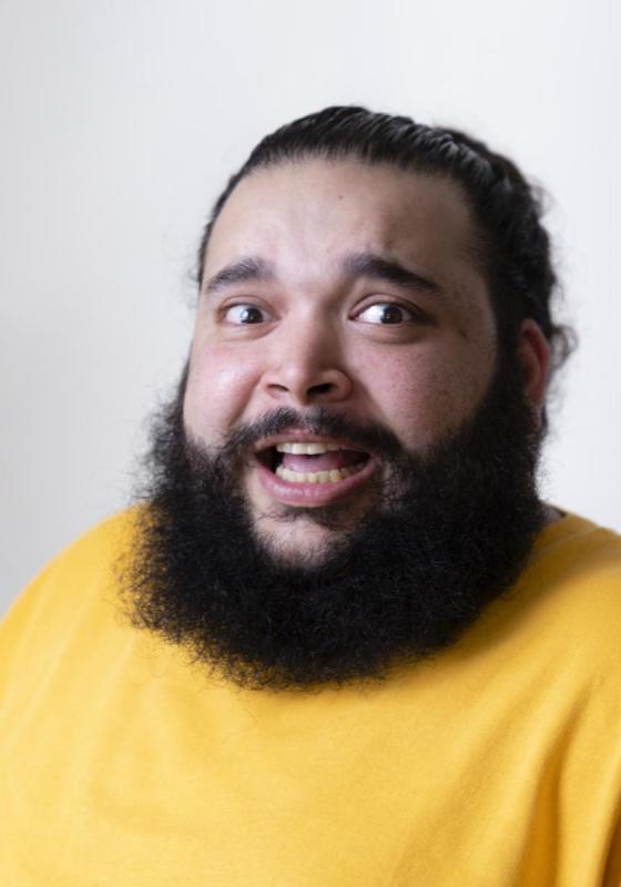 Headshot of Raj with a lovely full beard and wearing a vivid yellow jumper.