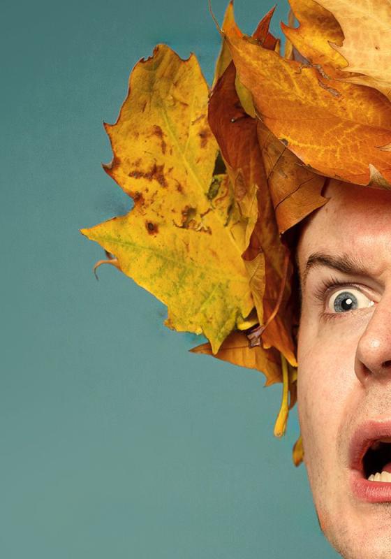 A man wearing a crown made of leaves with a shocked expression on his face