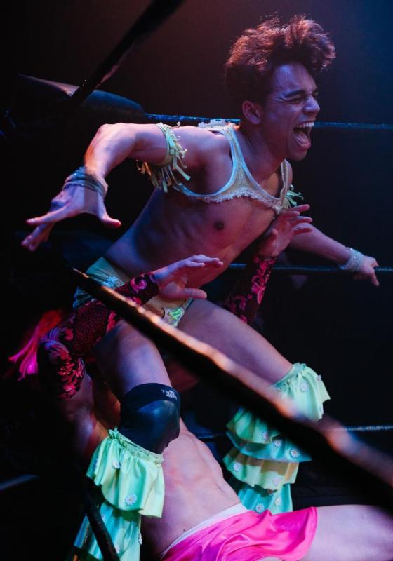 A performer, mid-action, throwing his bum in another performer's face