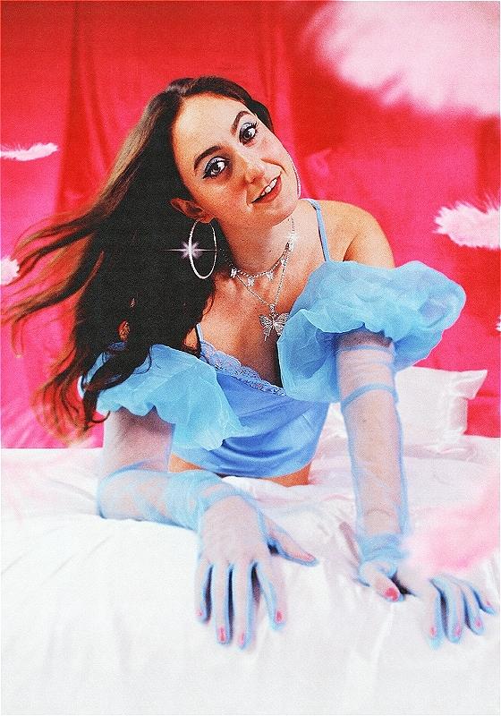 Catherine posed on a bed in a light blue dress & gloves. 