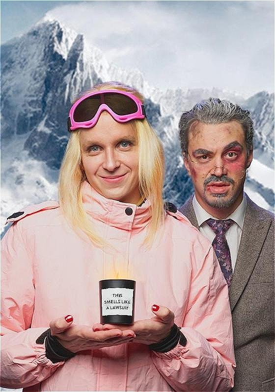 To the left Linus as Gwyneth in ski gear holding a candle that says 'smells like a lawsuit.' To the right Joseph as Terry looking dazed as if he's been in a ski accident.