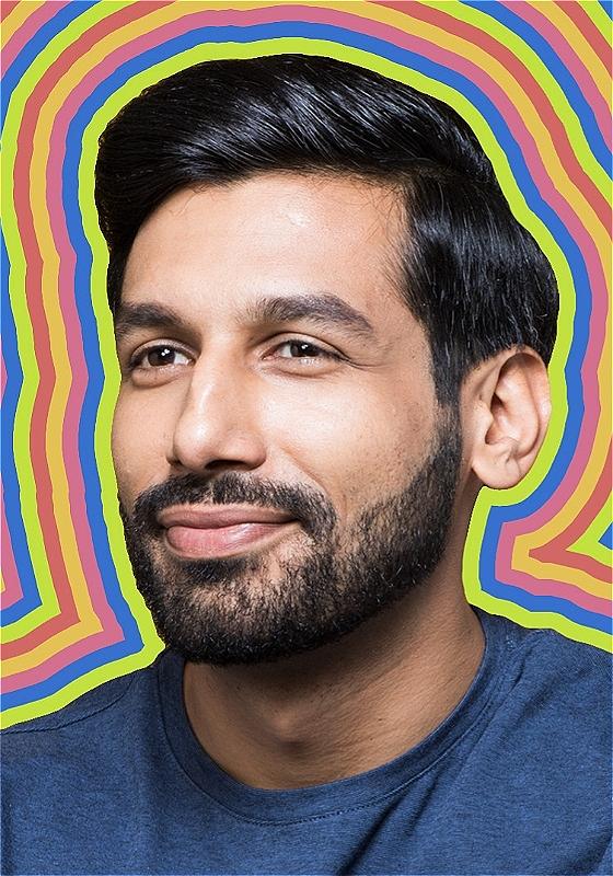 A close-up of the performer in a blue t-shirt with a multi-coloured background outlining his face