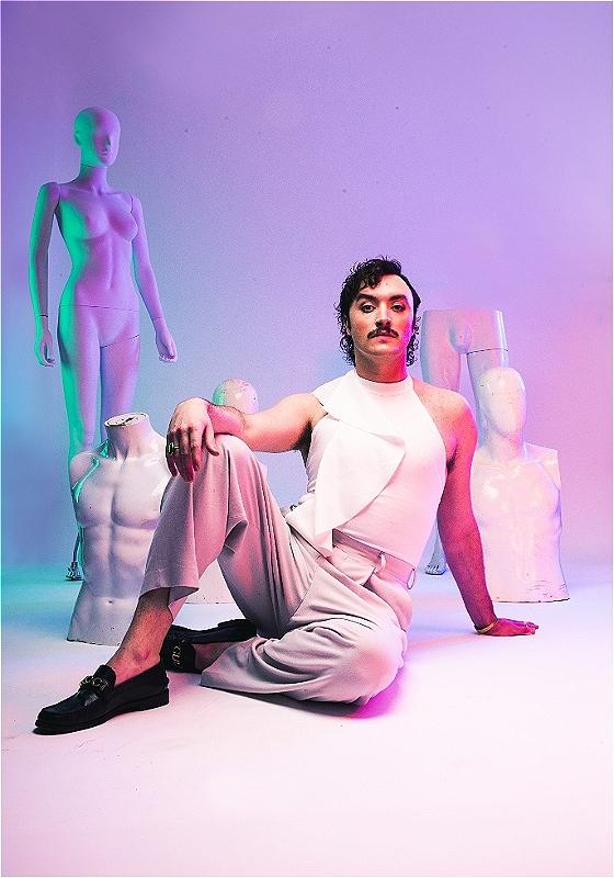 Dan sits on the floor surrounded by broken mannequins.