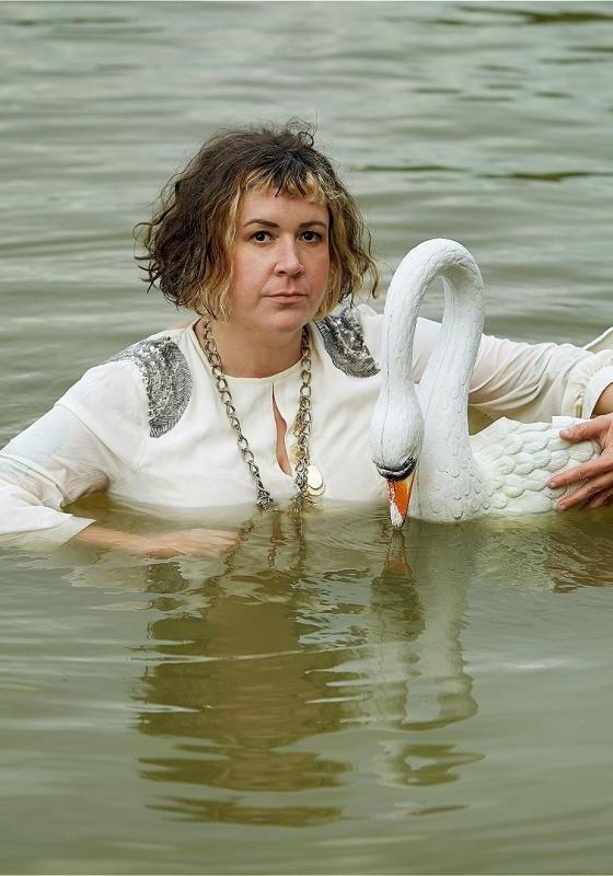 Amy submerged in the middle of a lake holding a plastic swan.