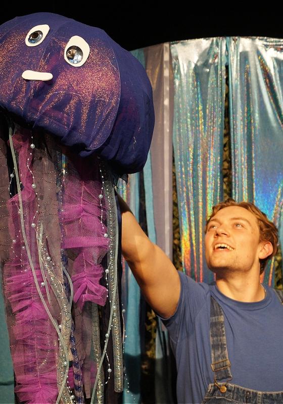 A man holding a stuffed jellyfish toy.