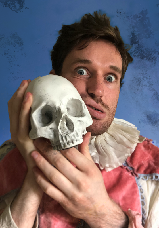 A person faces the camera in a Shakespearen outfit, leaning their head against a skull with a witchy look on their face. 