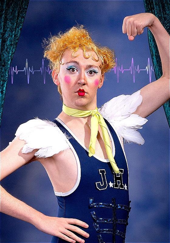 An illustration of the actor tensing their arms muscles. They are wearing a sports outfit with white feather shoulder pads. and sequined abs.