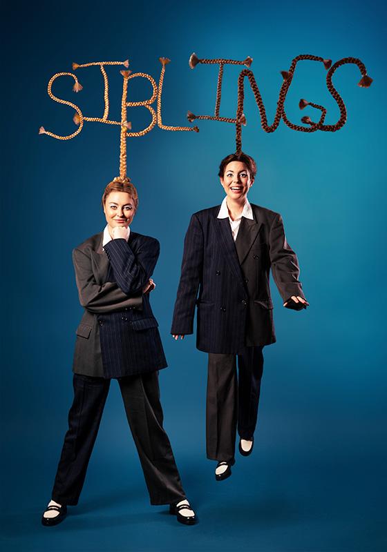 Siblings in suits look playfully at the camera with their braided to spell out the word SIBLINGS.