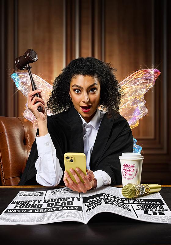 A fairy in a judge's outfit with a gavel in their hand looks with surprise into the camera. They are holding a yellow smartphone in their other hand. On their desk is a gold microphone, a coffee mug and a newspaper. 