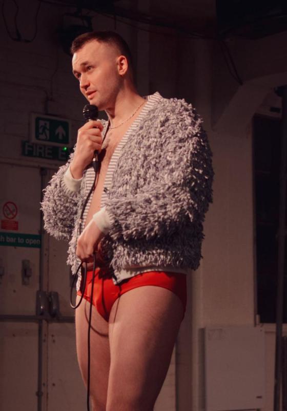 a person standing in red underwear and a  short fur coat 