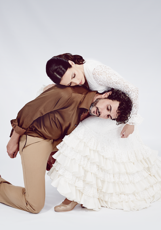Two dancers, one with their head resting on the other's knee.
