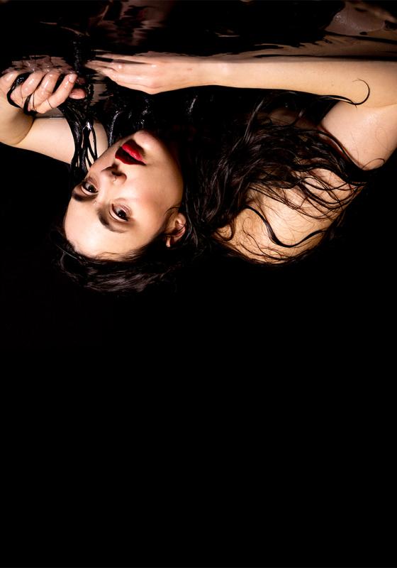 Marjolein resting her arms & head on a table. The image has then been flipped upside down.