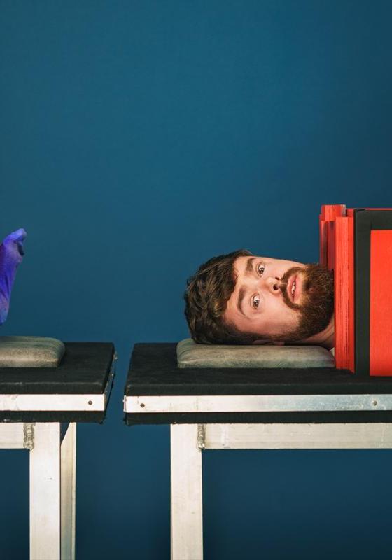 Tom Brace lies on a table sawed in half