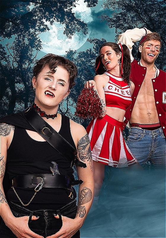 Count Dykula stands in front of two cheerleading humans.