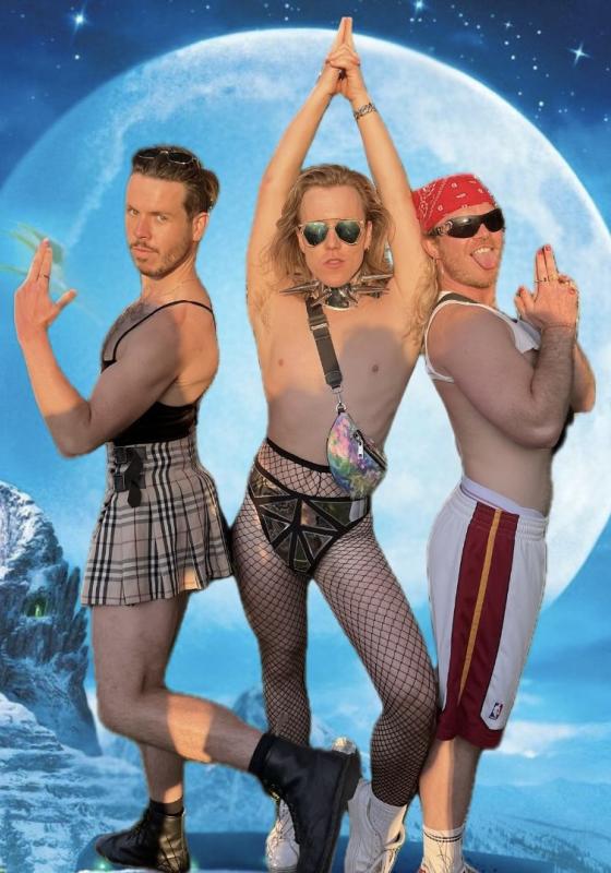 Three fabulous light-skinned people imitate the Charlie's Angels pose - the middle one pointing a finger gun sensually above their head, flanked by the other two pointing outwards. Fishnets and plaud skirts feature heavily, and two are wearing sunglasses. The background appears to be a massive moon against a starry sky, with a snowy mountain path extending in the background. It's all very Frozen.