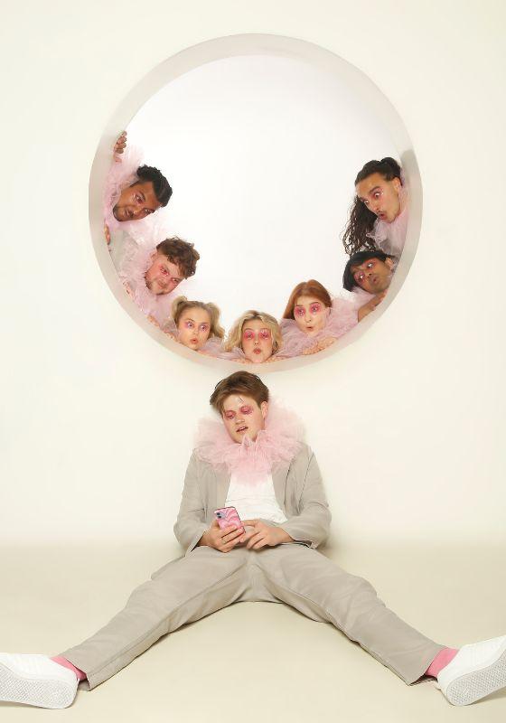 People in pink ruffs look out from a circular white window.
