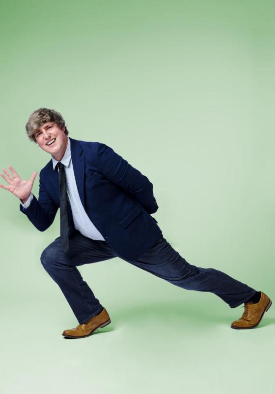 Glenn Moore in a deep lunge, smiling and waving at the camera.