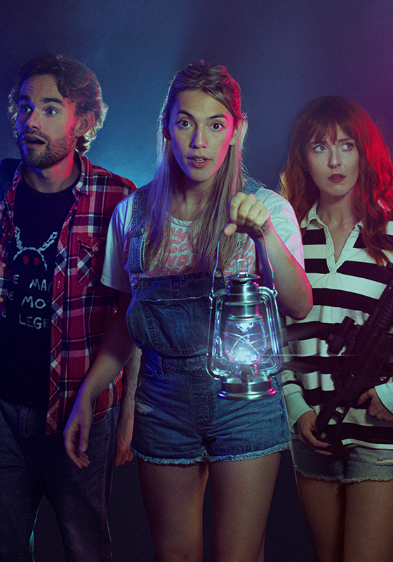Three people dimly lit holding a lantern