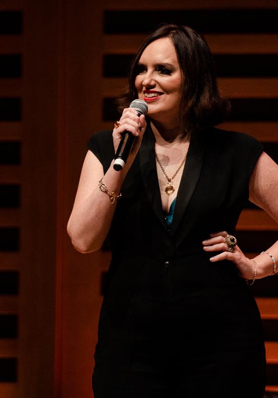 Deborah standing on stage with a mic