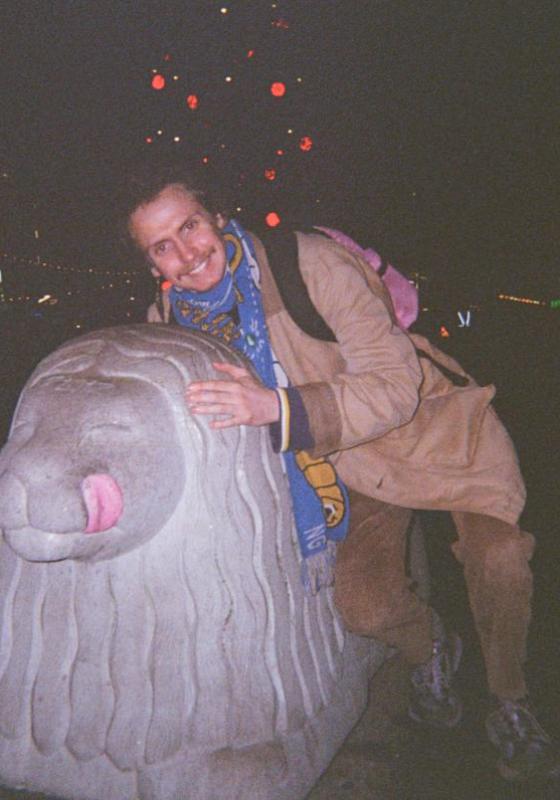 A film photo of Mikey posing with a statue