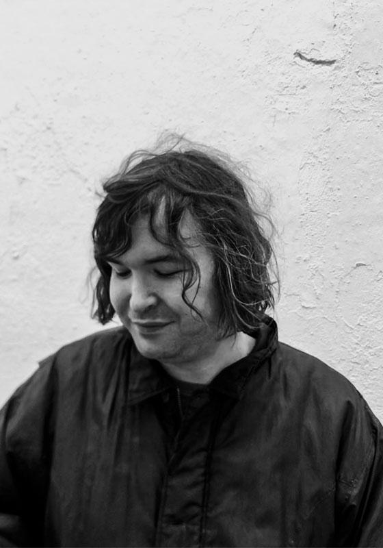 Black and white headshot of Johnny White looking down.