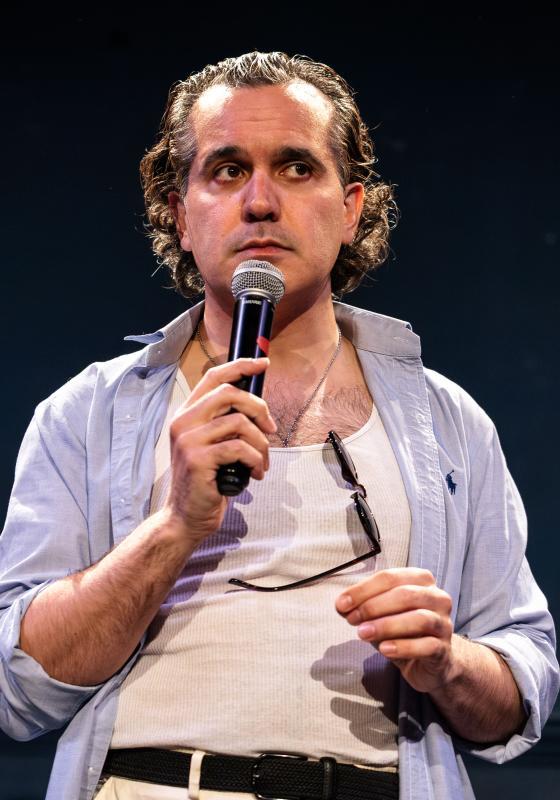 Sami holding a microphone performing stand up