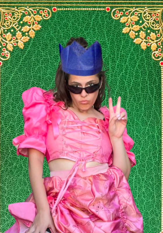 Clementine in a paper crown and sunglasses pouting at the camera