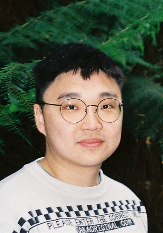 Photo of Jin Hao Li stood in frotn of a large fern.