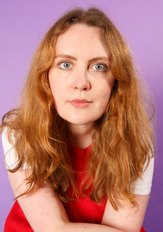 A closeup of Emmeline against a lilac background.