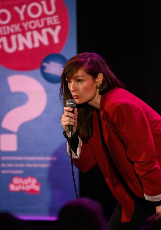 Photo of Madeleine on stage for the So You Think You're Funny competition.