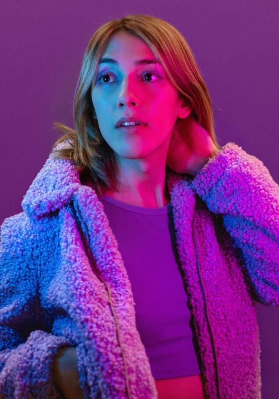 A photograph of the performer wearing a fluffy coat and crop top.