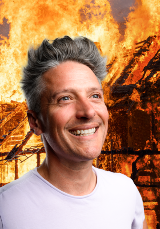 Stu grinning as a fire blazes in the background.