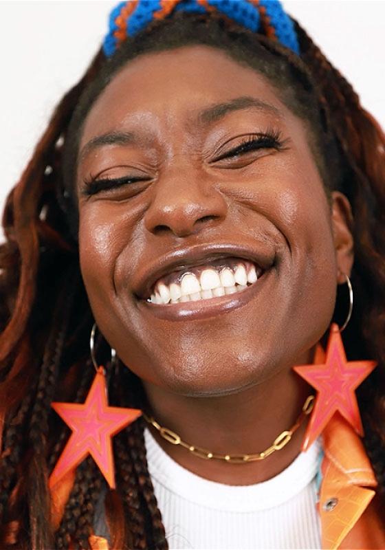 Photo of Sophie with a big smile and eyes partially closed in delight.