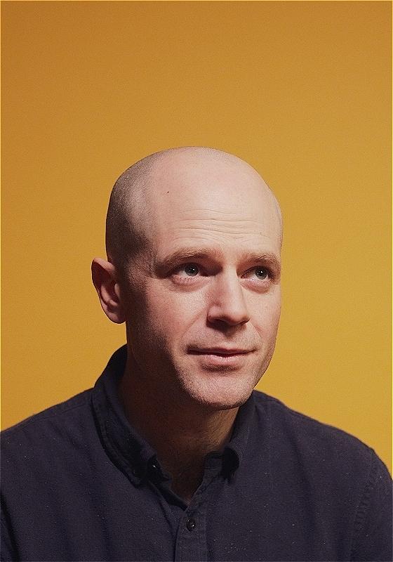 Photo of David Elms with a neutral expression looking up.