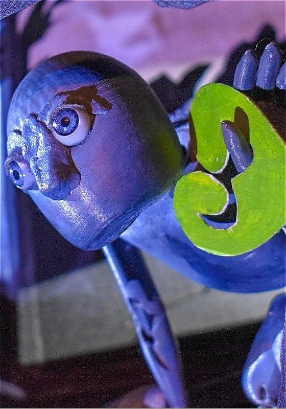 Closeup on a blue puppet holding a green leafy heart.