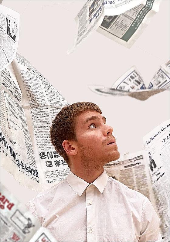 A person in a white button-up looks up as newspapers flutter down all around them. The background is white and it all feels very crisp.