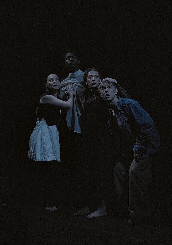 Four people in a dark room looking slightly unnerved 