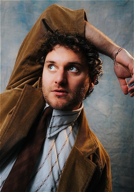 Closeup on Jonathan , who has his arm twisted over his head in a painful looking angle.