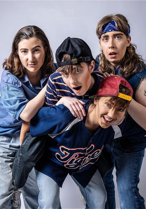 Four drag kings posing, as if for an album cover. 