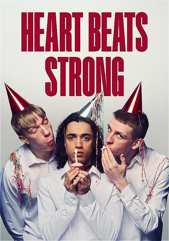 A person wearing a silver party hat holds a cupcake with a lit candle in it. Two people stand on either side of them, also wearing party hats. The person on the left is trying to blow the candle out and the person on the right is trying to light a cigarette in the flame. They are all wearing white shirts. The title of the show is in big red letters above the people. 