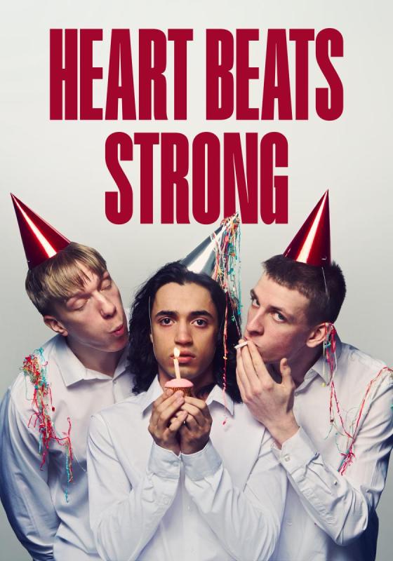 Three boys with party harts and white shirts. The middle boy holds a cupcake with a candle.