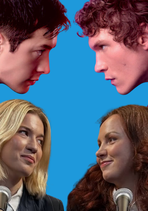 Two female comedians are in front of microphones against a backdrop with the main characters Shane and Ilya from Heated Rivalry